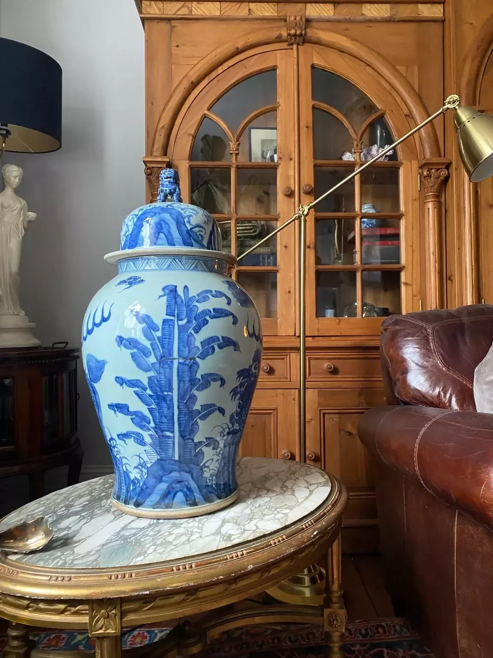 Blue and white decorative vase on a marble table with wooden cabinet in the background,available to buy from the-salon.com. SALON curates the finest unique handmade pieces from the interior industry's best makers and brands. Shop luxury furniture, lighting, rugs, art, antiques and vintage pieces and accessories from SALON interior designed rooms.