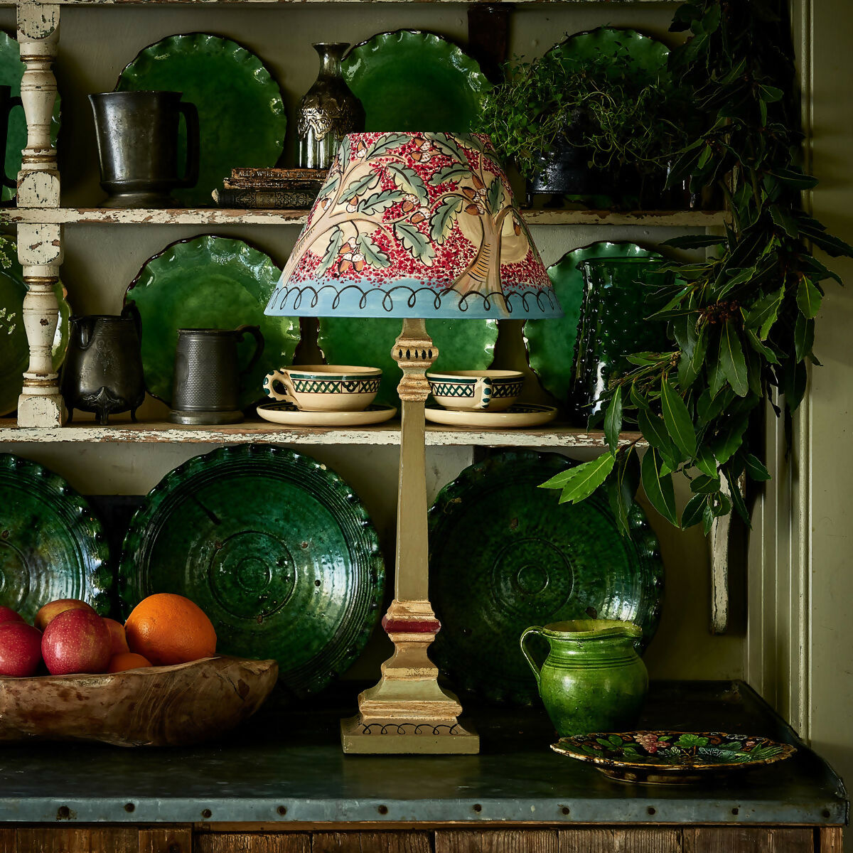 Decorative lamp with a colorful shade on a shelf with green plates and other items,  available  to buy on the-salon.com. SALON curates the finest , unique, handmade pieces from the interior industry's best makers and brands. Shop luxury furniture, lighting, rugs, art, antiques and vintage pieces and accessories from SALON interior designed rooms.