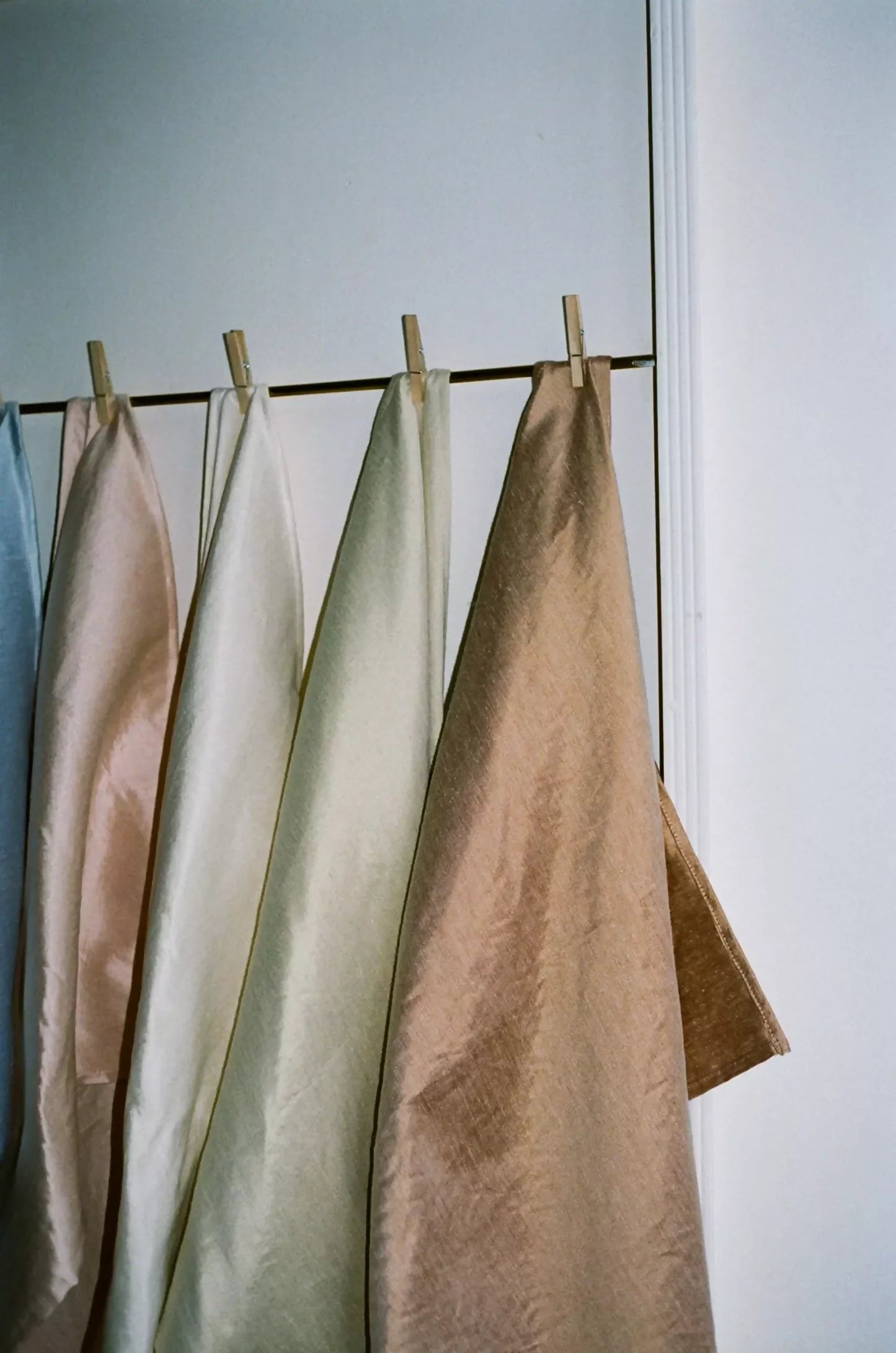 Close-up of a silk sateen fabrics in a pale green, soft brown, off-white and light salmon, showing the texture and sheen,  available  to buy on the-salon.com. SALON curates the finest , unique, handmade pieces from the interior industry's best makers and brands. Shop luxury furniture, lighting, rugs, art, antiques and vintage pieces and accessories from SALON interior designed rooms.