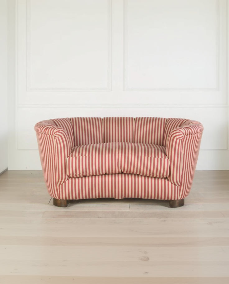 Red and white striped sofa on a light wooden floor with a white wall background