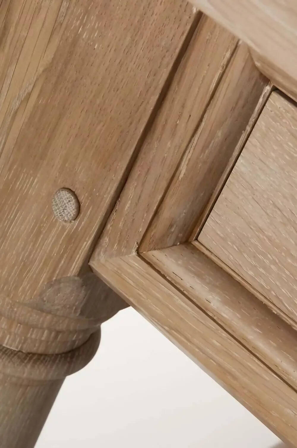 A rectangular wooden refectory table with a drawer at each end and columnar supports, a close up on the wood supports,  available  to buy on the-salon.com. SALON curates the finest , unique, handmade pieces from the interior industry's best makers and brands. Shop luxury furniture, lighting, rugs, art, antiques and vintage pieces and accessories from SALON interior designed rooms.