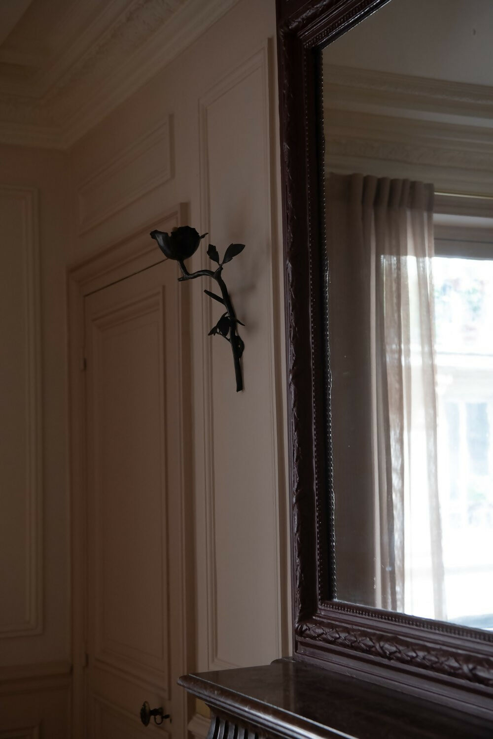 A wall-mounted black iron candle sconce in the shape of a clematis flower,  available  to buy on the-salon.com. SALON curates the finest , unique, handmade pieces from the interior industry's best makers and brands. Shop luxury furniture, lighting, rugs, art, antiques and vintage pieces and accessories from SALON interior designed rooms.