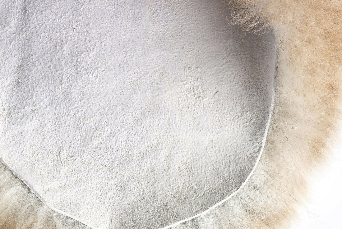 Close up of a white fur sheepskin rug. The rug, available to buy from the-salon.com. SALON curates the finest unique handmade pieces from the interior industry's best makers and brands. Shop luxury furniture, lighting, rugs, art, antiques and vintage pieces and accessories from SALON interior designed rooms.
