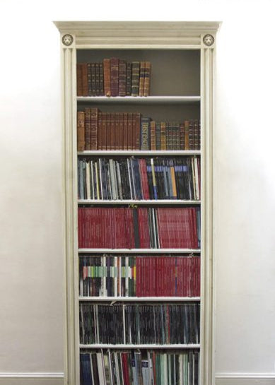 Tall bookshelf filled with books against a white wall,  available  to buy on the-salon.com. SALON curates the finest , unique, handmade pieces from the interior industry's best makers and brands. Shop luxury furniture, lighting, rugs, art, antiques and vintage pieces and accessories from SALON interior designed rooms.