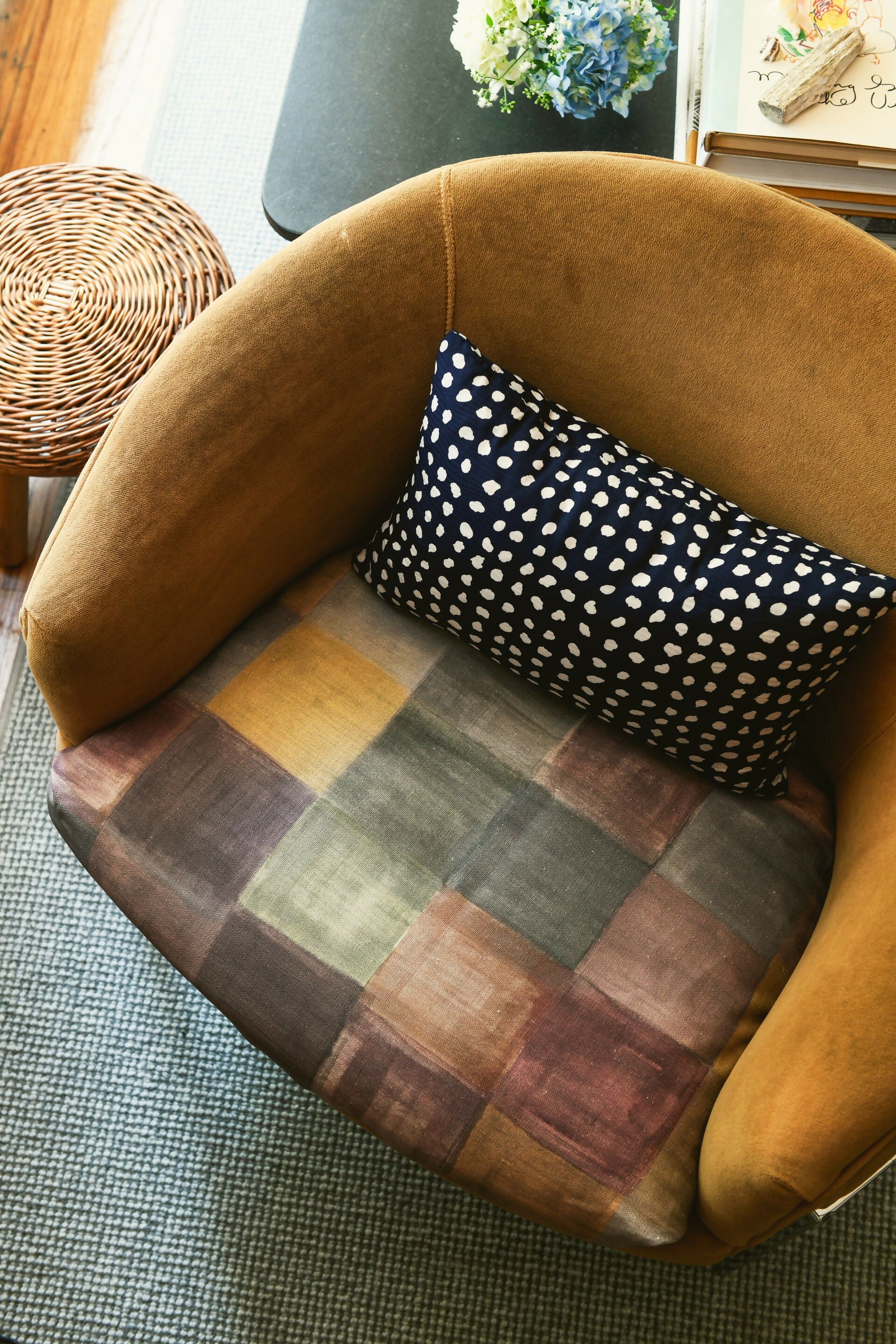 A close-up of a plaid fabric on a chair featuring a pattern of various solid colors, including blue, pink, green, and yellow,  available  to buy on the-salon.com. SALON curates the finest , unique, handmade pieces from the interior industry's best makers and brands. Shop luxury furniture, lighting, rugs, art, antiques and vintage pieces and accessories from SALON interior designed rooms.