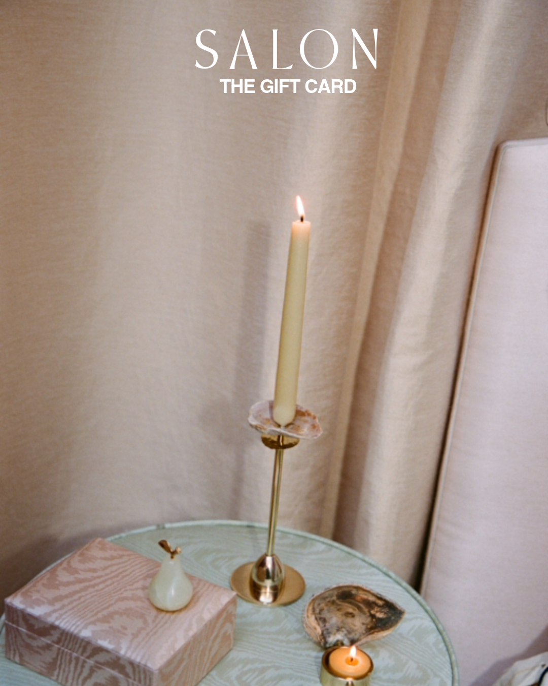 Candle on a table with 'SALON THE GIFT CARD' text overlay