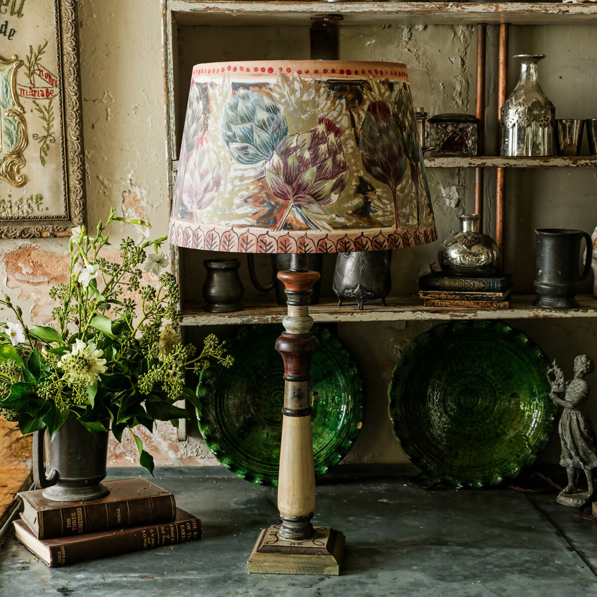 Decorative lamp with floral shade on a rustic shelf with books and plants,  available  to buy on the-salon.com. SALON curates the finest , unique, handmade pieces from the interior industry's best makers and brands. Shop luxury furniture, lighting, rugs, art, antiques and vintage pieces and accessories from SALON interior designed rooms.
