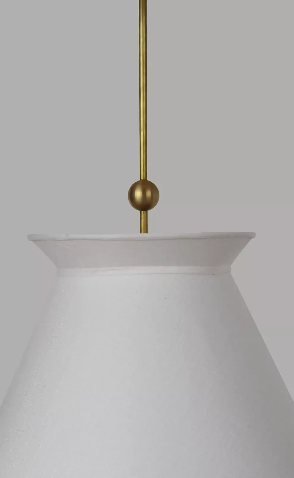 A pendant light with a pleated shade hanging over a dining table with a floral arrangement in the center, with curtains in the background, available  to buy on the-salon.com. SALON curates the finest , unique, handmade pieces from the interior industry's best makers and brands. Shop luxury furniture, lighting, rugs, art, antiques and vintage pieces and accessories from SALON interior designed rooms.