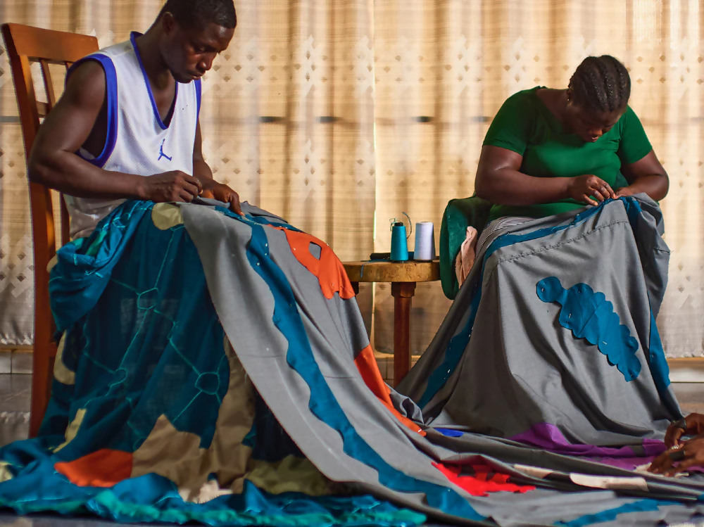 An image of two people working on the wall hanging,  available  to buy on the-salon.com. SALON curates the finest , unique, handmade pieces from the interior industry's best makers and brands. Shop luxury furniture, lighting, rugs, art, antiques and vintage pieces and accessories from SALON interior designed rooms.