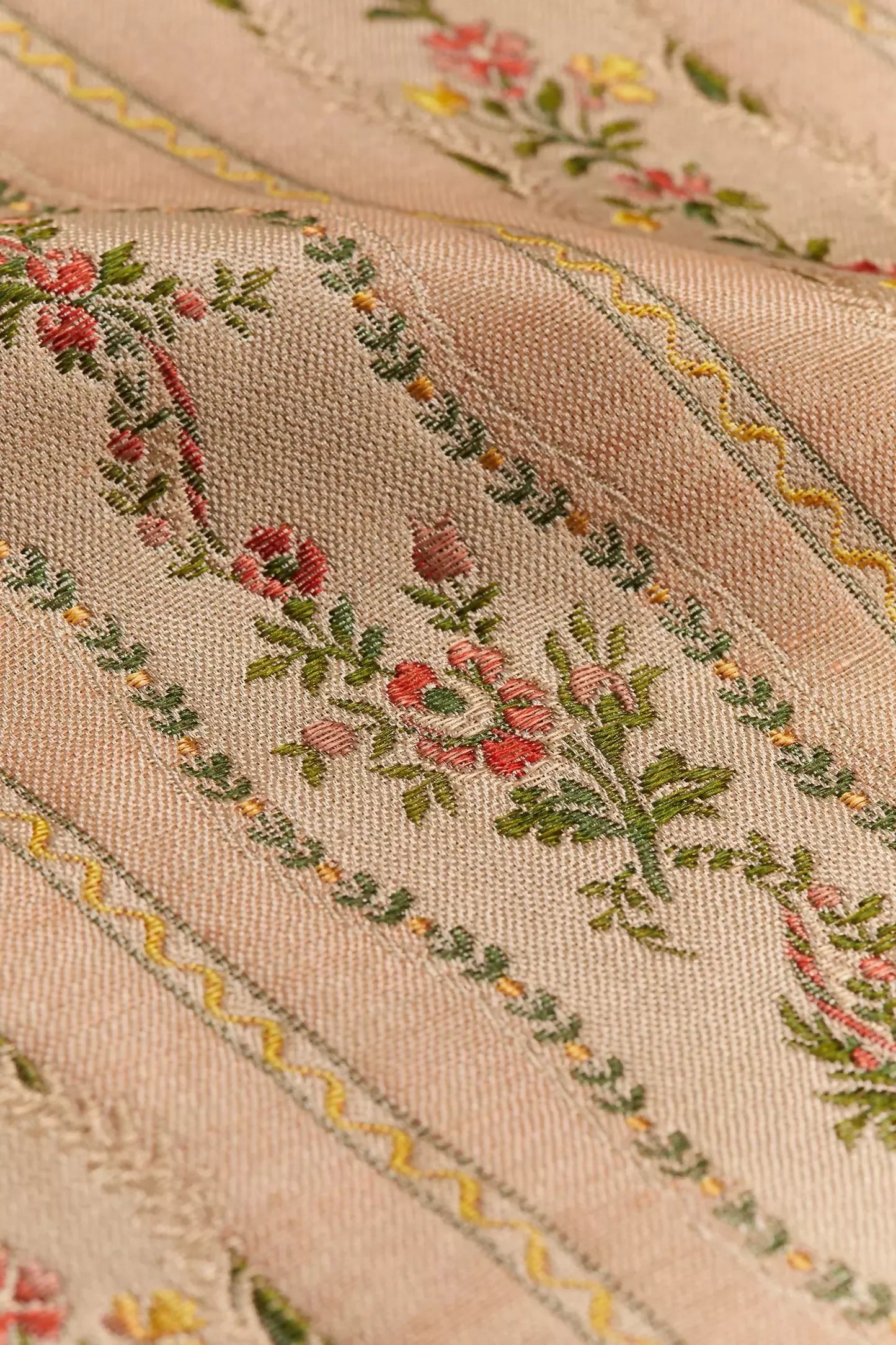Close-up of Spitalfields stripe blush fabric with a jacquard weave showcasing floral motifs and silk edges,  available  to buy on the-salon.com. SALON curates the finest , unique, handmade pieces from the interior industry's best makers and brands. Shop luxury furniture, lighting, rugs, art, antiques and vintage pieces and accessories from SALON interior designed rooms.