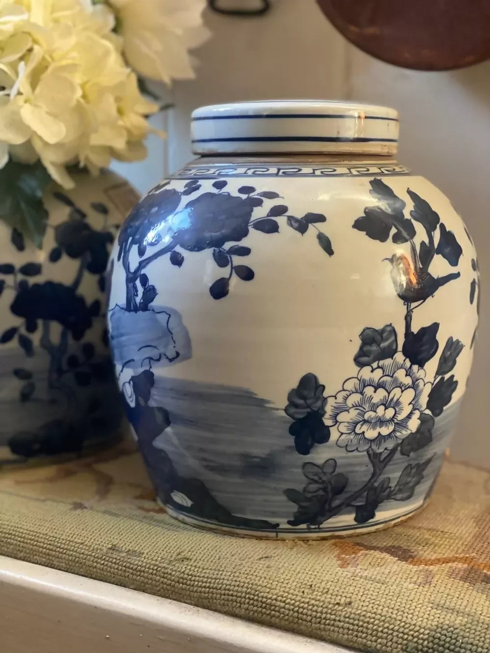 Blue and white ceramic jar with floral design on a textured surface,  available  to buy on the-salon.com. SALON curates the finest , unique, handmade pieces from the interior industry's best makers and brands. Shop luxury furniture, lighting, rugs, art, antiques and vintage pieces and accessories from SALON interior designed rooms.