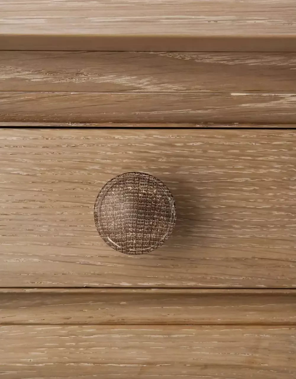 Close-up on the handles on a rectangular wooden refectory table with a drawer at each end and columnar supports, designed in a natural brown finish,  available  to buy on the-salon.com. SALON curates the finest , unique, handmade pieces from the interior industry's best makers and brands. Shop luxury furniture, lighting, rugs, art, antiques and vintage pieces and accessories from SALON interior designed rooms.