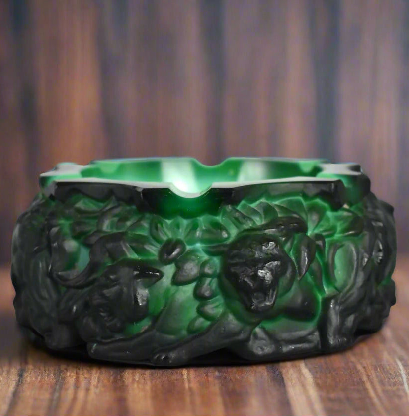 An image of a dark green glass ashtray depicting panthers in the undergrowth. 
SALON curates the finest unique handmade pieces from the interior industry's best makers and brands. Shop luxury furniture, lighting, rugs, art, antiques and vintage pieces and accessories from SALON interior designed rooms. 