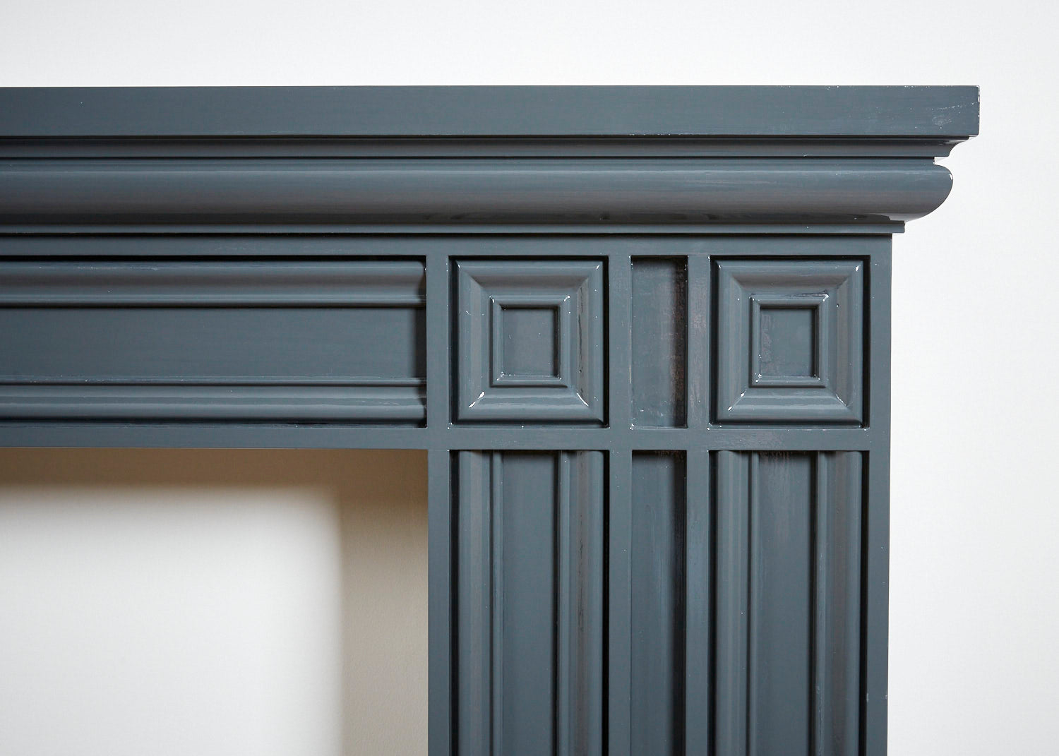 An image of a close up on the handcrafted wood on a dark grey fireplace,  available  to buy on the-salon.com. SALON curates the finest , unique, handmade pieces from the interior industry's best makers and brands. Shop luxury furniture, lighting, rugs, art, antiques and vintage pieces and accessories from SALON interior designed rooms.
