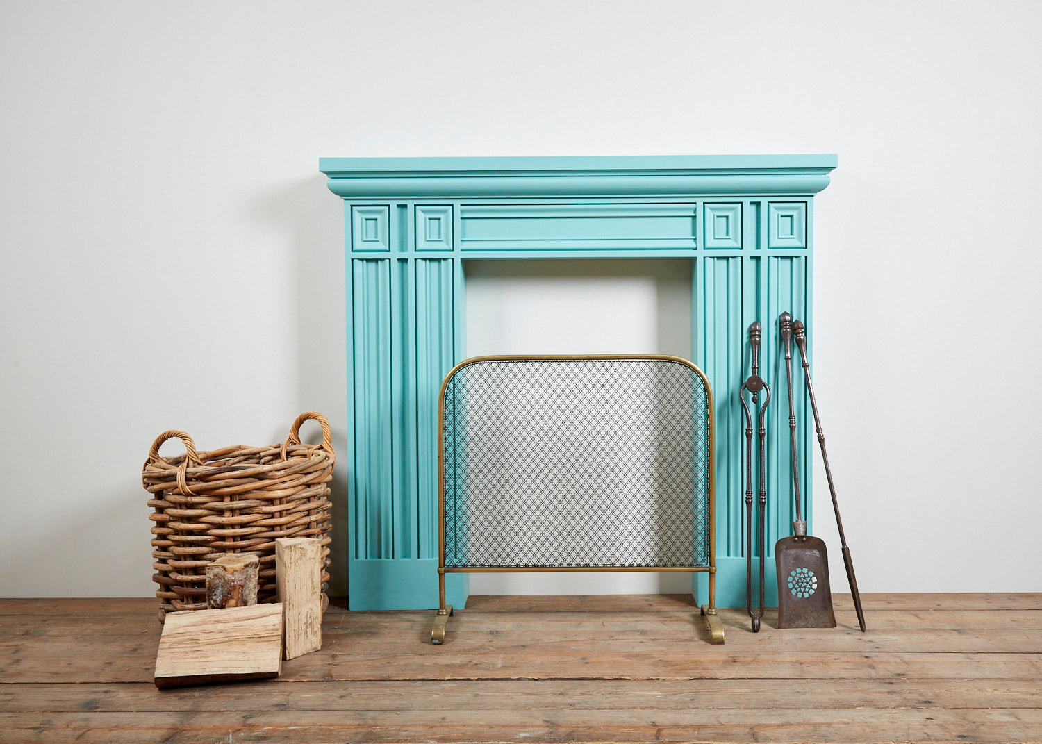 An image of a light blue fireplace on a white wall with wood in the foreground,  available  to buy on the-salon.com. SALON curates the finest , unique, handmade pieces from the interior industry's best makers and brands. Shop luxury furniture, lighting, rugs, art, antiques and vintage pieces and accessories from SALON interior designed rooms.