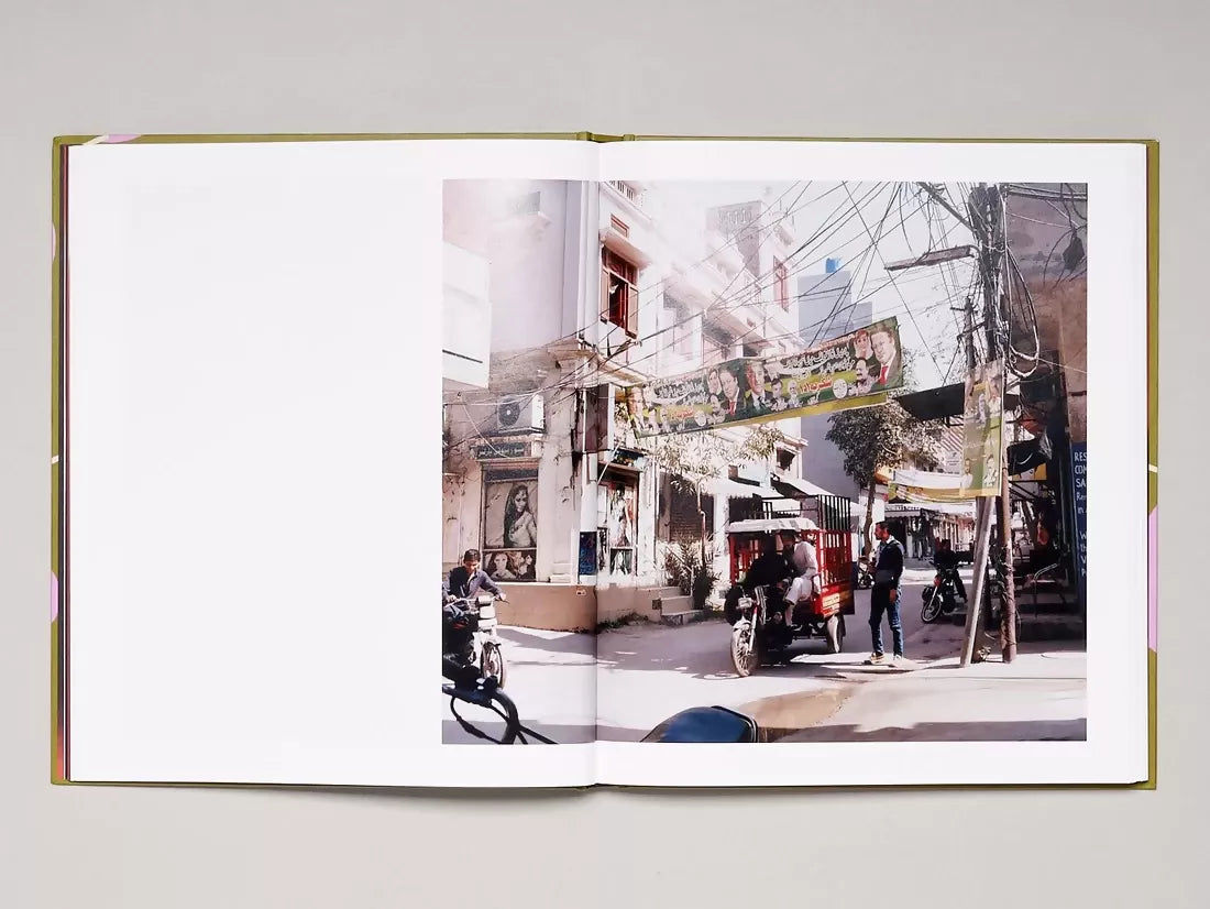 Open book, page open to a large image of a busy street, with bikes on the road and signs up above,  available  to buy on the-salon.com. SALON curates the finest , unique, handmade pieces from the interior industry's best makers and brands. Shop luxury furniture, lighting, rugs, art, antiques and vintage pieces and accessories from SALON interior designed rooms.