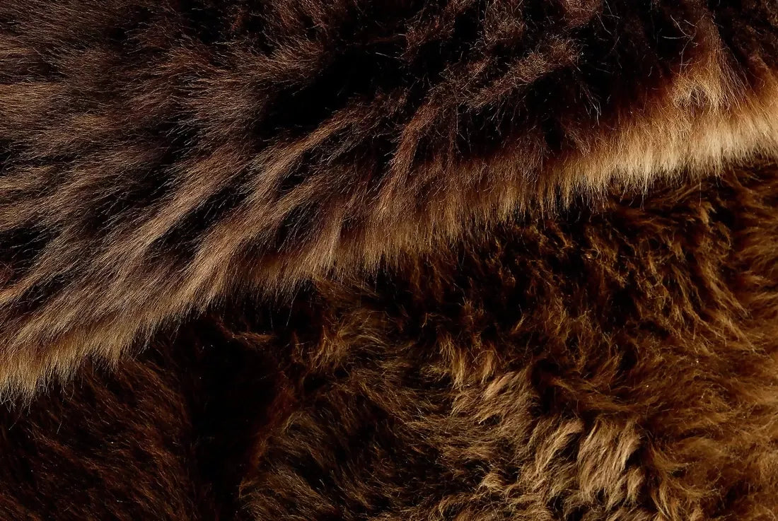 Close up of a brown  sheepskin fur rug. The rug, available to buy from the-salon.com. SALON curates the finest unique handmade pieces from the interior industry's best makers and brands. Shop luxury furniture, lighting, rugs, art, antiques and vintage pieces and accessories from SALON interior designed rooms.