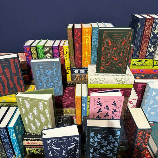 A collection of clothbound hardcover books with colorful covers, featuring a variety of classic novel designs,  available  to buy on the-salon.com. SALON curates the finest , unique, handmade pieces from the interior industry's best makers and brands. Shop luxury furniture, lighting, rugs, art, antiques and vintage pieces and accessories from SALON interior designed rooms.