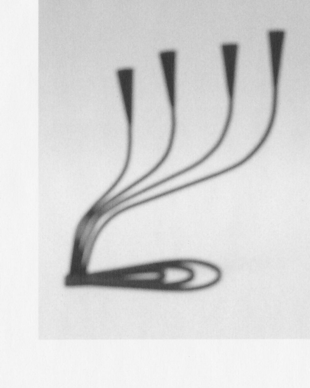 A black, hand forged iron candle holder with four curved arms and cone shaped heads, on a white background,  available  to buy on the-salon.com. SALON curates the finest , unique, handmade pieces from the interior industry's best makers and brands. Shop luxury furniture, lighting, rugs, art, antiques and vintage pieces and accessories from SALON interior designed rooms.