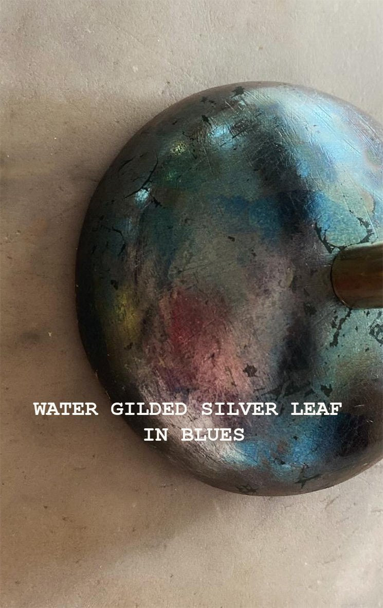 A close up on the base of the wall lamp, in the colour 'water gilded silver leaf in blues, available  to buy on the-salon.com. SALON curates the finest , unique, handmade pieces from the interior industry's best makers and brands. Shop luxury furniture, lighting, rugs, art, antiques and vintage pieces and accessories from SALON interior designed rooms.