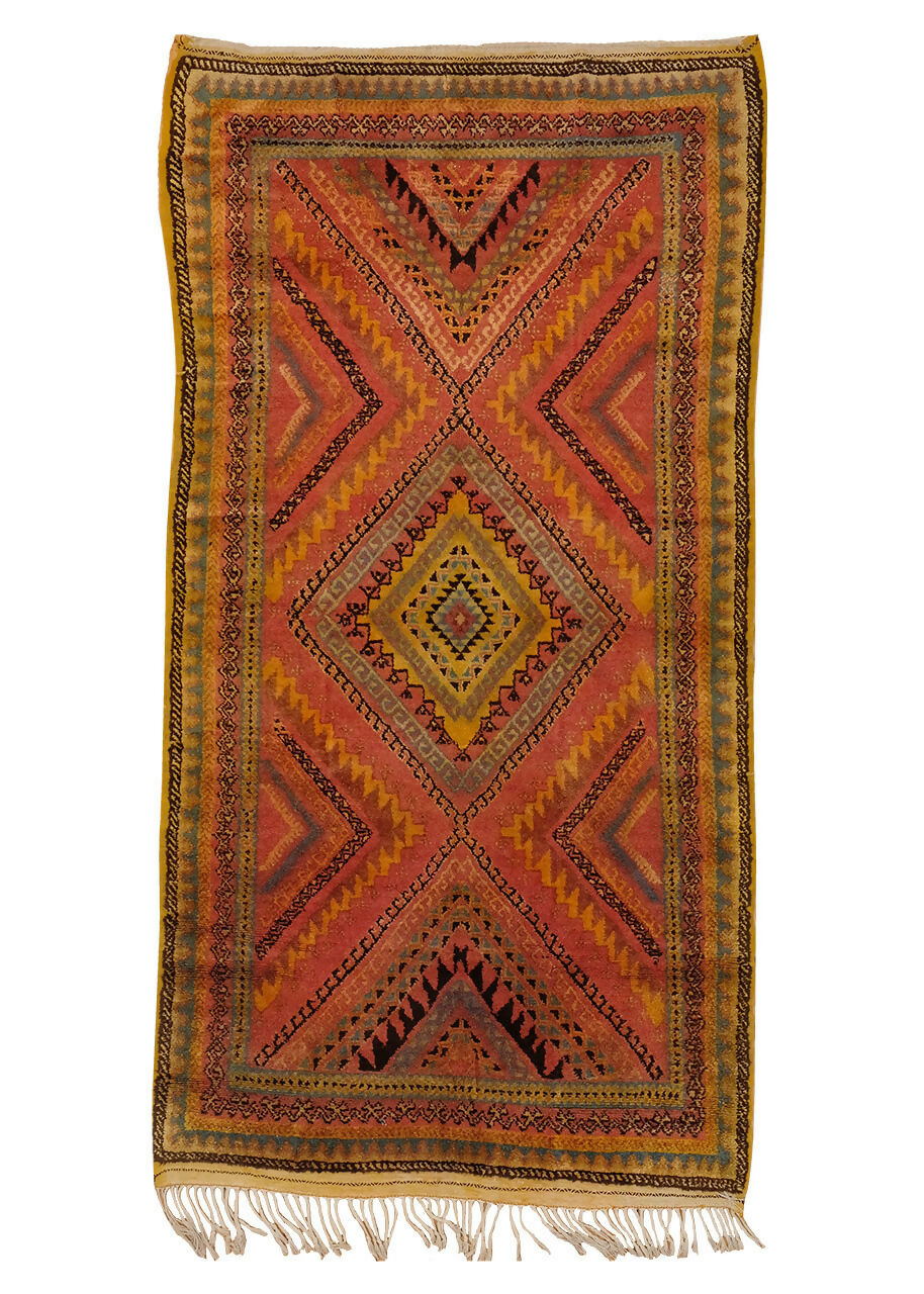 A vintage Moroccan wool hand knotted rug with a bold central diamond medallion and vibrant zigzag patterns, featuring a warm color palette,  available  to buy on the-salon.com. SALON curates the finest , unique, handmade pieces from the interior industry's best makers and brands. Shop luxury furniture, lighting, rugs, art, antiques and vintage pieces and accessories from SALON interior designed rooms.