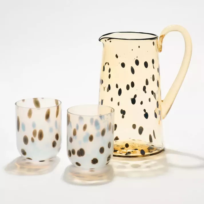 Glass pitcher and two glasses with a spotted pattern on a white background, available  to buy on the-salon.com. SALON curates the finest , unique, handmade pieces from the interior industry's best makers and brands. Shop luxury furniture, lighting, rugs, art, antiques and vintage pieces and accessories from SALON interior designed rooms.