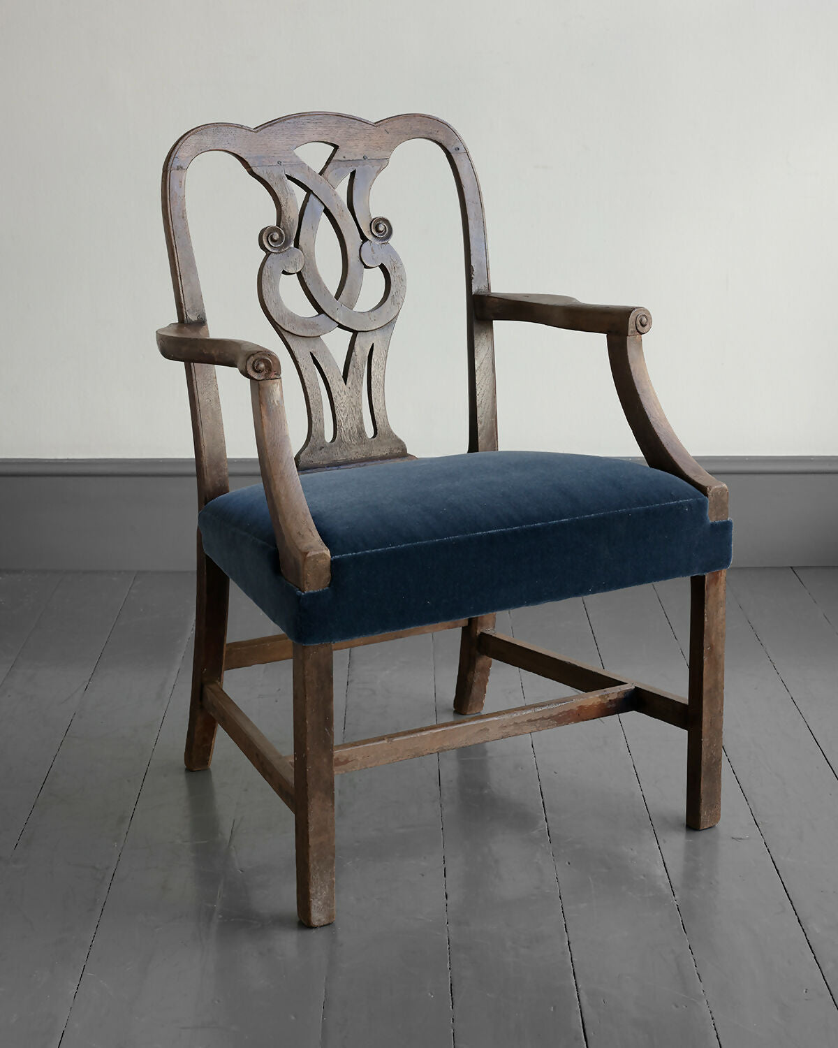 Wooden chair with a blue cushion on a gray floor,available to buy from the-salon.com. SALON curates the finest unique handmade pieces from the interior industry's best makers and brands. Shop luxury furniture, lighting, rugs, art, antiques and vintage pieces and accessories from SALON interior designed rooms. 