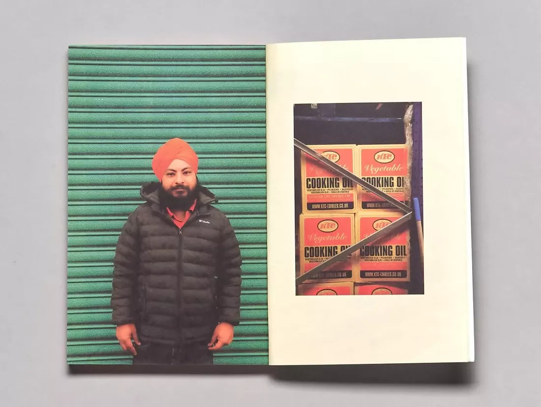 An open book, pages to a man wearing a red turban infant of green shutters and the other page being large amounts of packaged cooking oil, available  to buy on the-salon.com. SALON curates the finest , unique, handmade pieces from the interior industry's best makers and brands. Shop luxury furniture, lighting, rugs, art, antiques and vintage pieces and accessories from SALON interior designed rooms.