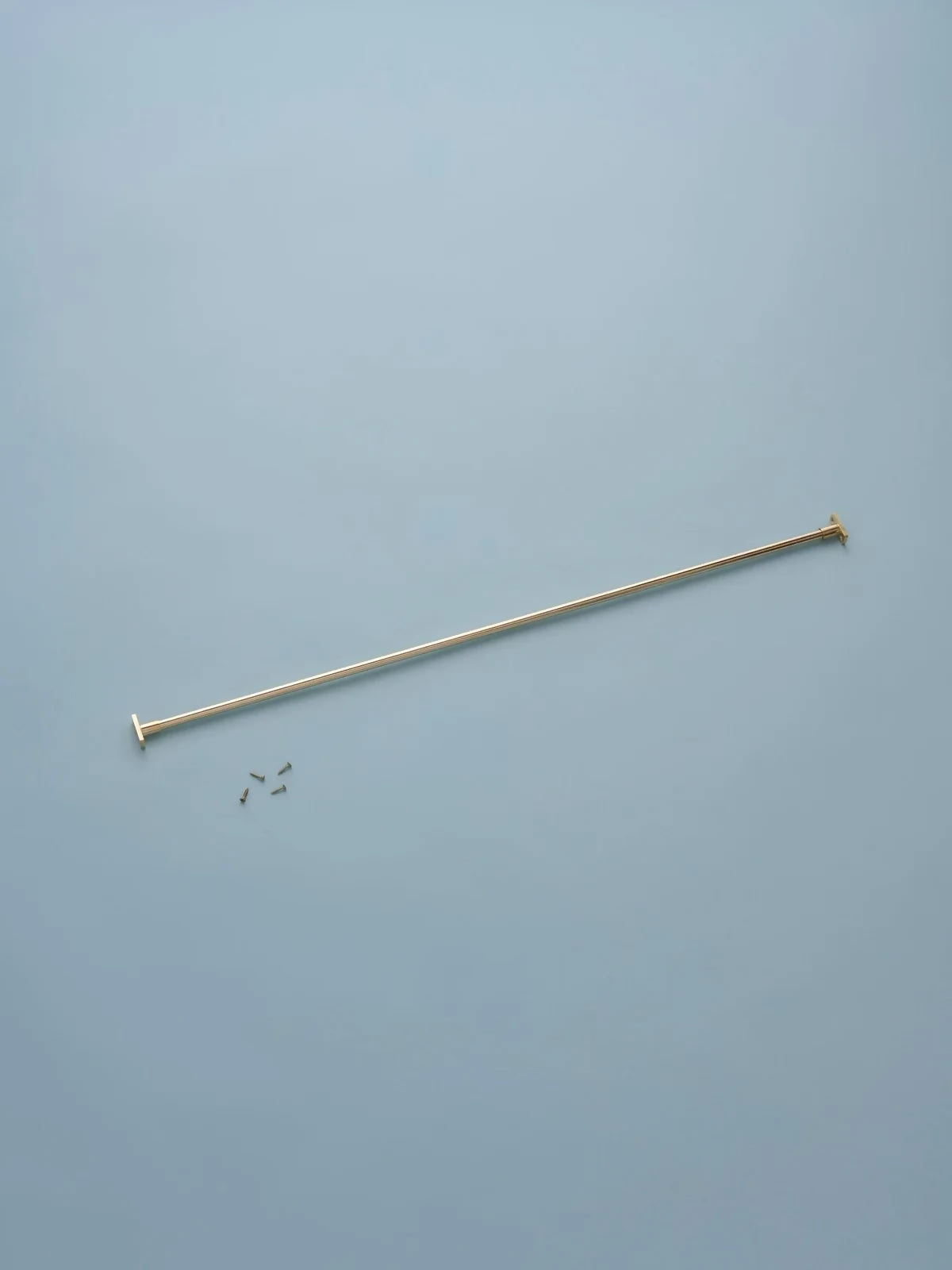 Gold-colored metal rod on a light blue background,  available  to buy on the-salon.com. SALON curates the finest , unique, handmade pieces from the interior industry's best makers and brands. Shop luxury furniture, lighting, rugs, art, antiques and vintage pieces and accessories from SALON interior designed rooms.