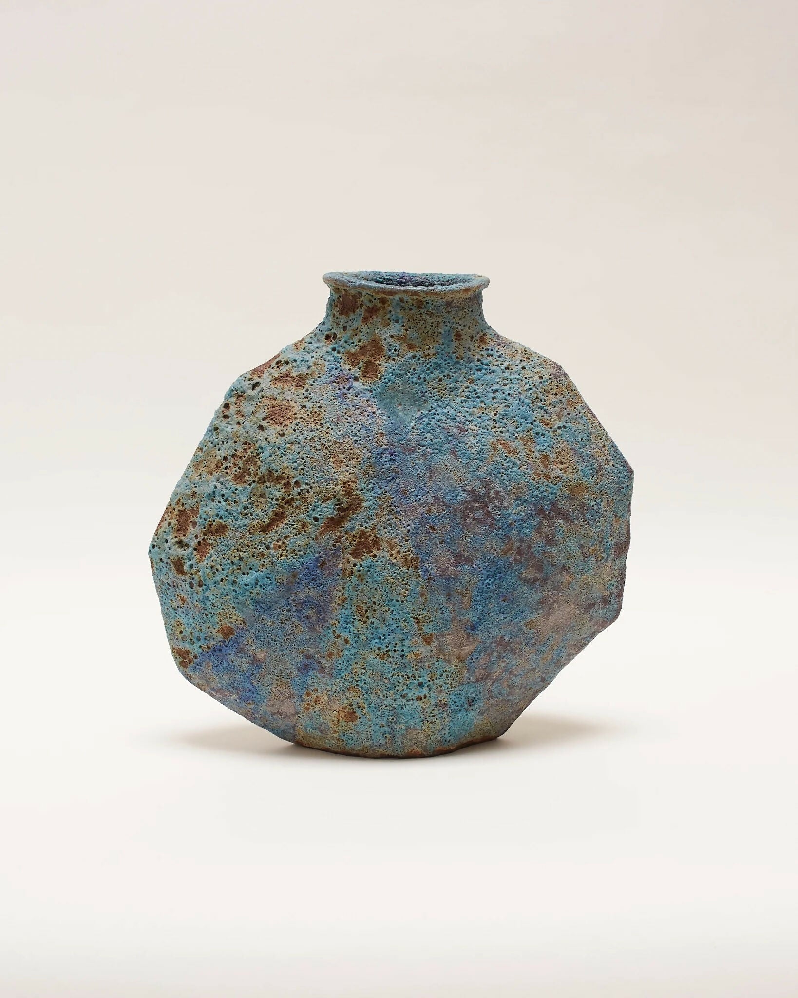 A ceramic vase with an angular form and a vibrant textural glaze in turquoise, blue, and subtle green tones,  available  to buy on the-salon.com. SALON curates the finest , unique, handmade pieces from the interior industry's best makers and brands. Shop luxury furniture, lighting, rugs, art, antiques and vintage pieces and accessories from SALON interior designed rooms.