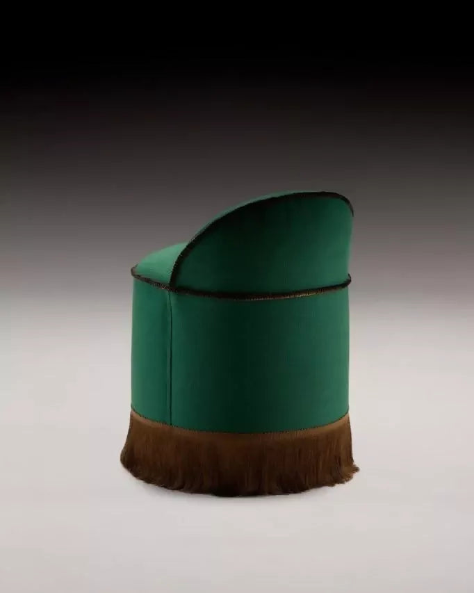 A green upholstered Inferi stool with a curvilinear backrest and a brown fringe at the base, designed for room service or salon use,  available  to buy on the-salon.com. SALON curates the finest , unique, handmade pieces from the interior industry's best makers and brands. Shop luxury furniture, lighting, rugs, art, antiques and vintage pieces and accessories from SALON interior designed rooms.
