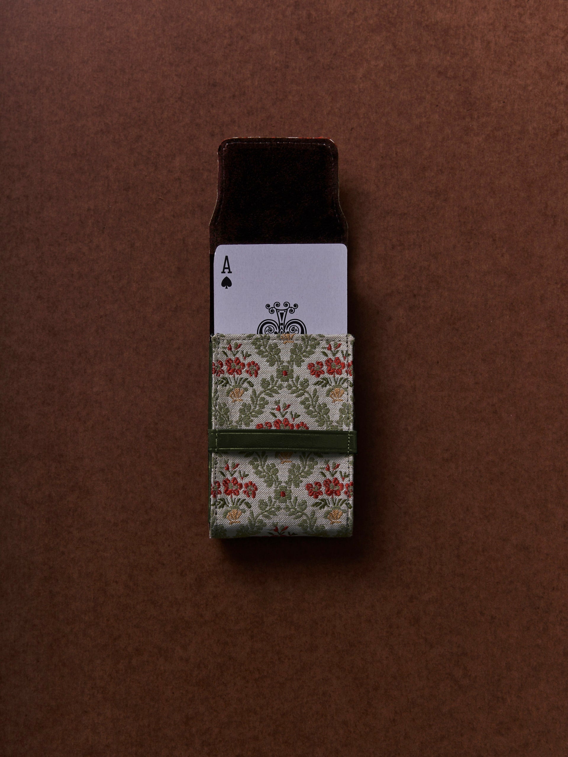 Floral-patterned card case with playing card design on a brown background,  available  to buy on the-salon.com. SALON curates the finest , unique, handmade pieces from the interior industry's best makers and brands. Shop luxury furniture, lighting, rugs, art, antiques and vintage pieces and accessories from SALON interior designed rooms.