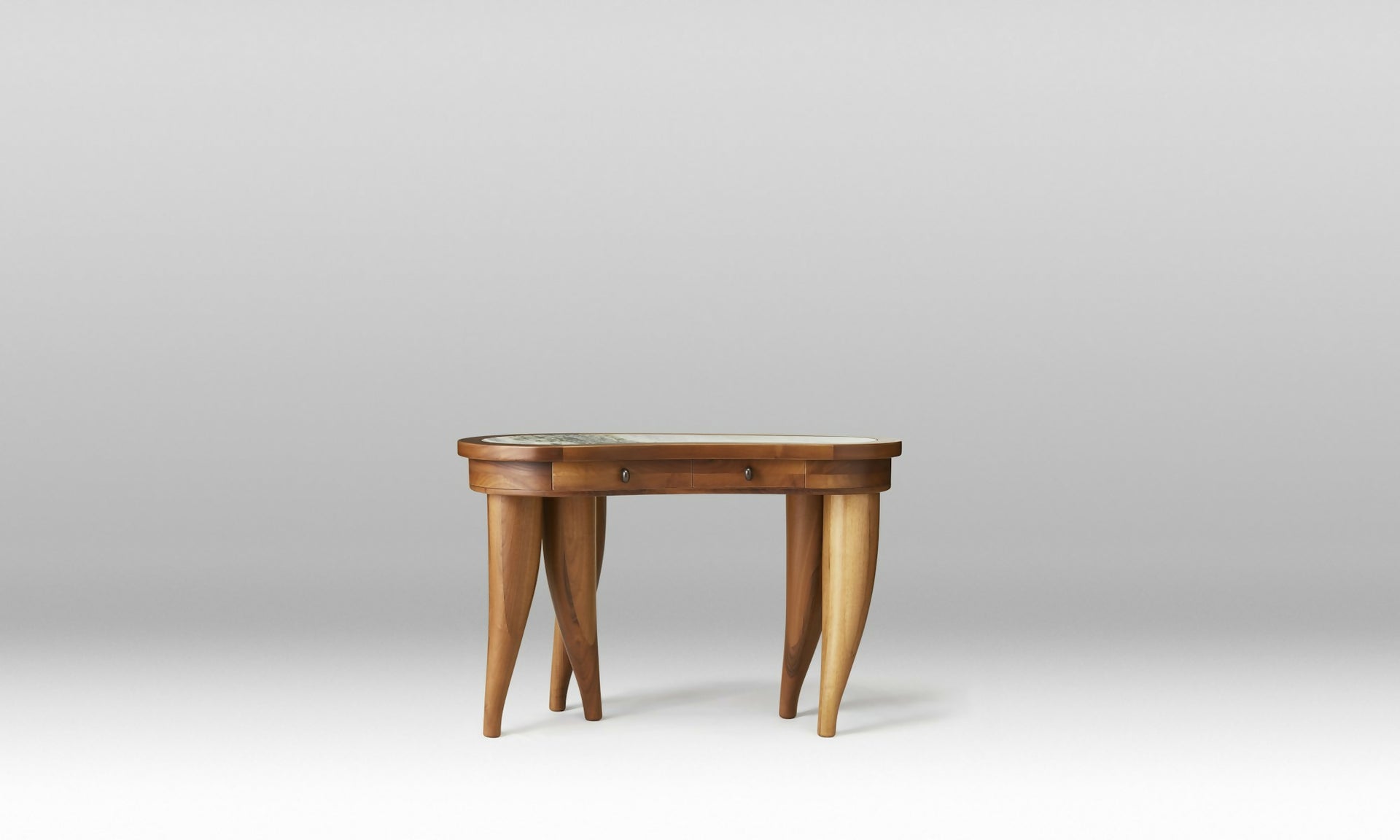 A wooden desk with a curved, organic shape and solid wood legs, featuring a marble top with brass hardware and leather inlay drawers,  available  to buy on the-salon.com. SALON curates the finest , unique, handmade pieces from the interior industry's best makers and brands. Shop luxury furniture, lighting, rugs, art, antiques and vintage pieces and accessories from SALON interior designed rooms.