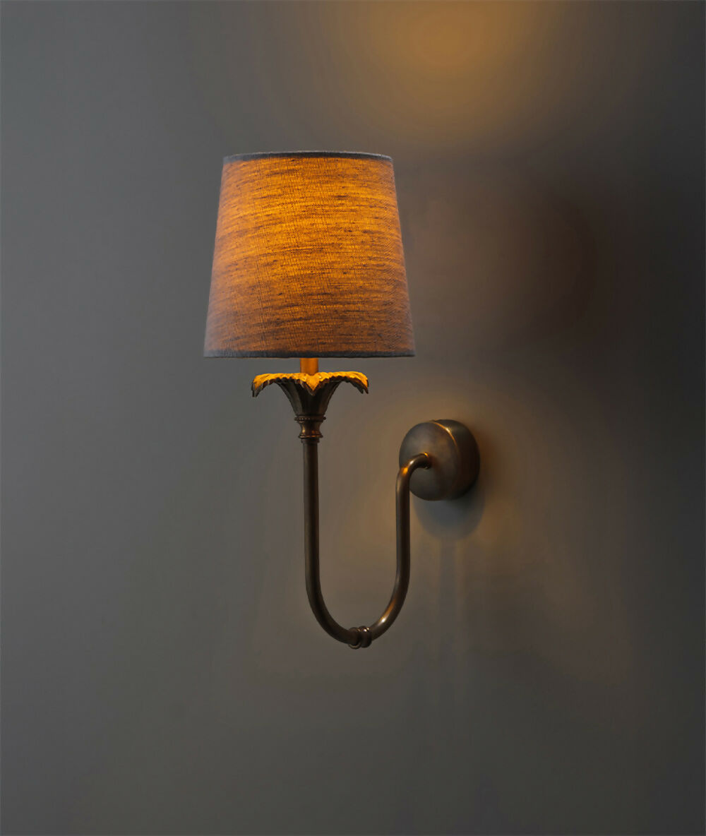 Wall-mounted lamp with brown shade and metallic base on a dark background, available  to buy on the-salon.com. SALON curates the finest , unique, handmade pieces from the interior industry's best makers and brands. Shop luxury furniture, lighting, rugs, art, antiques and vintage pieces and accessories from SALON interior designed rooms.