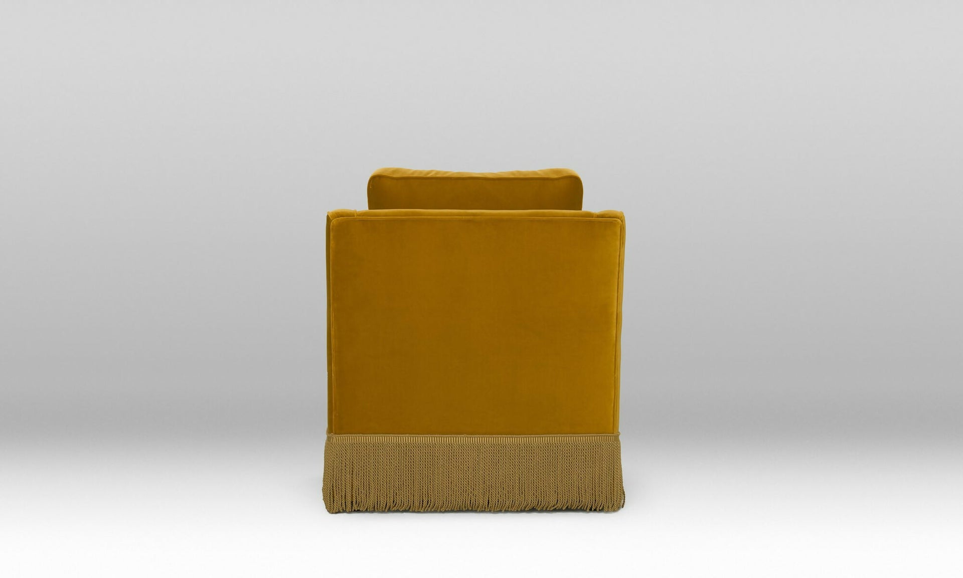 The back of a Mustard yellow armchair with fringes on a white background, available  to buy on the-salon.com. SALON curates the finest , unique, handmade pieces from the interior industry's best makers and brands. Shop luxury furniture, lighting, rugs, art, antiques and vintage pieces and accessories from SALON interior designed rooms.