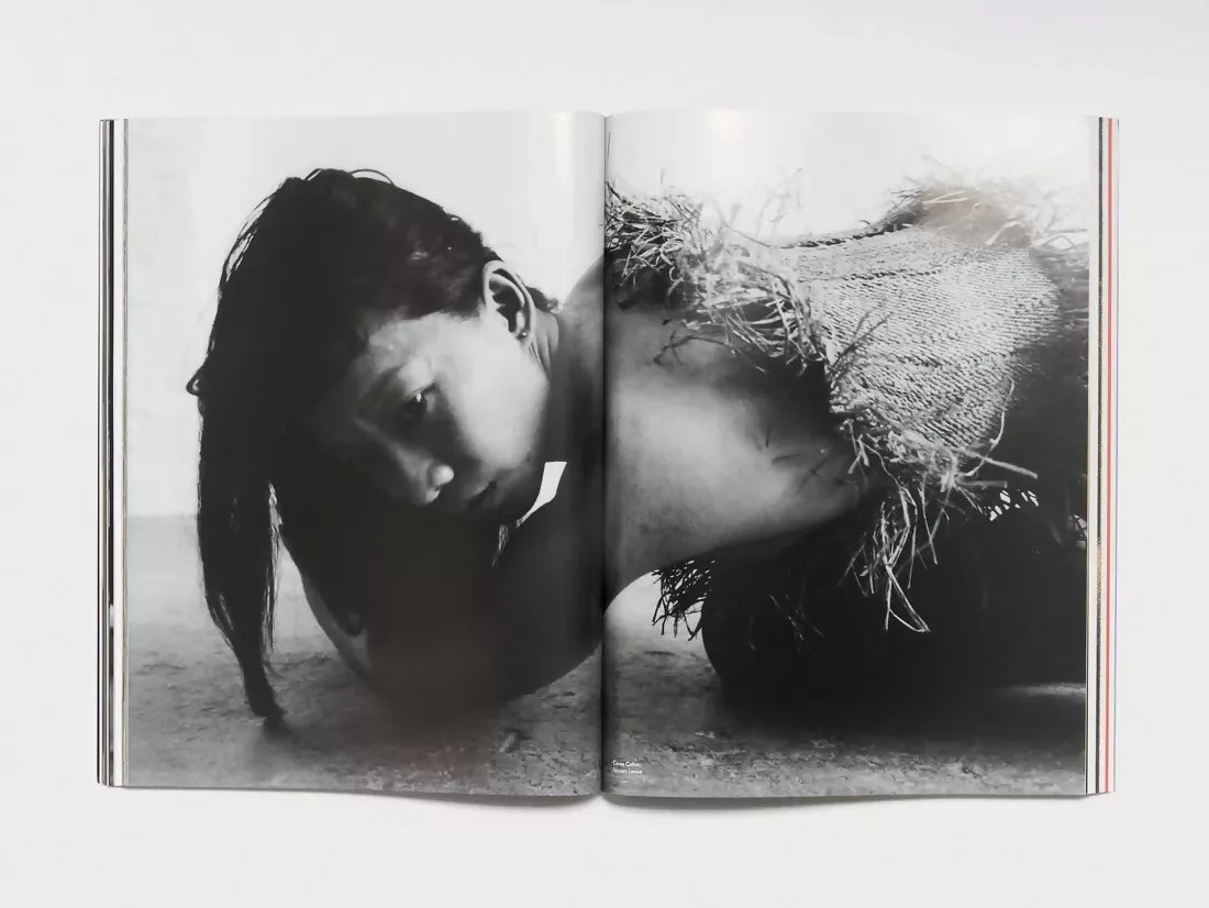 An open book, pages to a large image of a woman knelt on the floor wearing a cut up sack, available  to buy on the-salon.com. SALON curates the finest , unique, handmade pieces from the interior industry's best makers and brands. Shop luxury furniture, lighting, rugs, art, antiques and vintage pieces and accessories from SALON interior designed rooms.