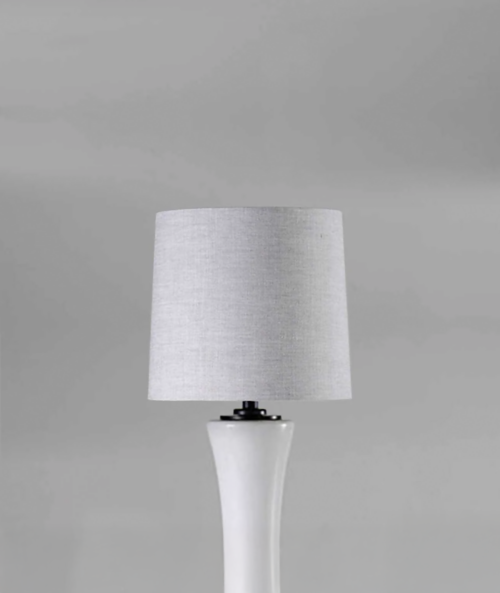 Table lamp with a gray shade on a gray background, available  to buy on the-salon.com. SALON curates the finest , unique, handmade pieces from the interior industry's best makers and brands. Shop luxury furniture, lighting, rugs, art, antiques and vintage pieces and accessories from SALON interior designed rooms.