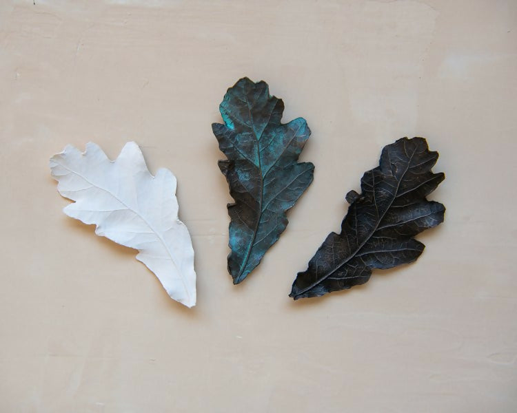 White, green and dark bronze leaf-shaped sculptures at various angles on a light background, available  to buy on the-salon.com. SALON curates the finest , unique, handmade pieces from the interior industry's best makers and brands. Shop luxury furniture, lighting, rugs, art, antiques and vintage pieces and accessories from SALON interior designed rooms.