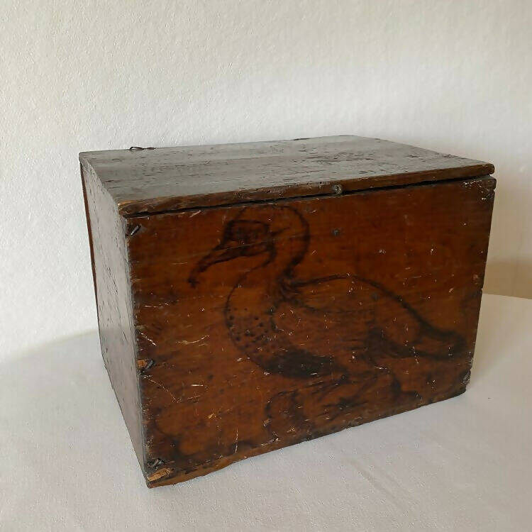 An 1800s wooden box with a carved bird, identified as a 'Pelican', on its surface, available  to buy on the-salon.com. SALON curates the finest , unique, handmade pieces from the interior industry's best makers and brands. Shop luxury furniture, lighting, rugs, art, antiques and vintage pieces and accessories from SALON interior designed rooms.