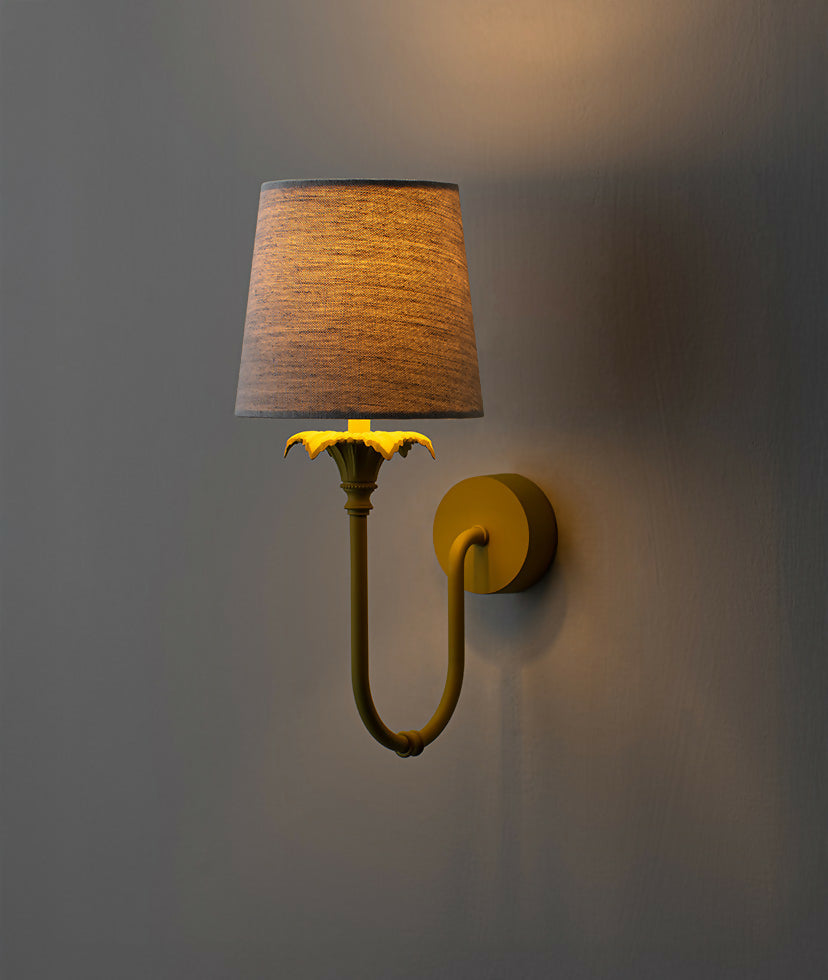 A wall-mounted light fixture with a yellow-colored metal arm and a white, solid-patterned lampshade,  available  to buy on the-salon.com. SALON curates the finest , unique, handmade pieces from the interior industry's best makers and brands. Shop luxury furniture, lighting, rugs, art, antiques and vintage pieces and accessories from SALON interior designed rooms.