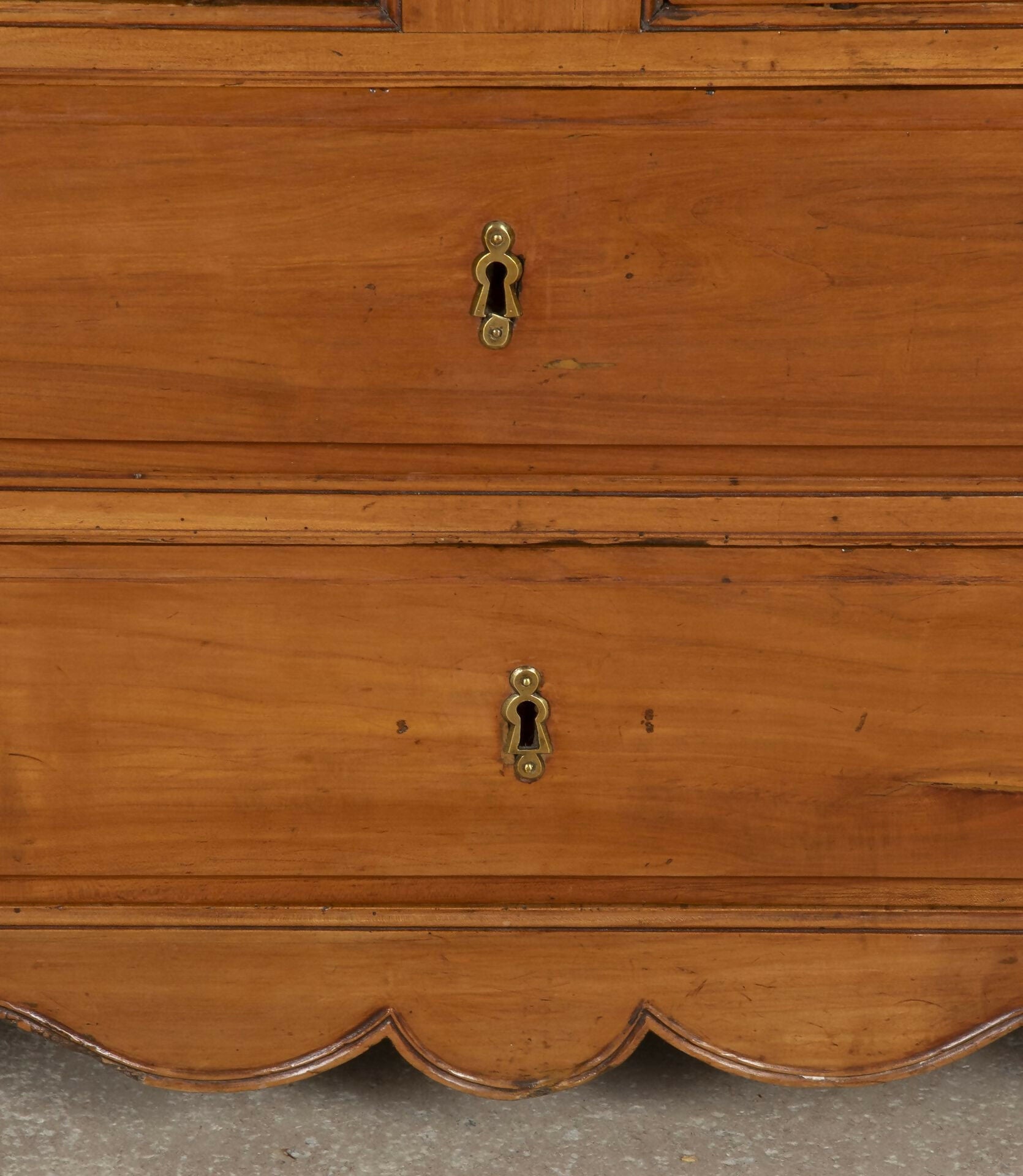 Close-up of a wooden dresser with visible keyholes on a gray surface,  available  to buy on the-salon.com. SALON curates the finest , unique, handmade pieces from the interior industry's best makers and brands. Shop luxury furniture, lighting, rugs, art, antiques and vintage pieces and accessories from SALON interior designed rooms.