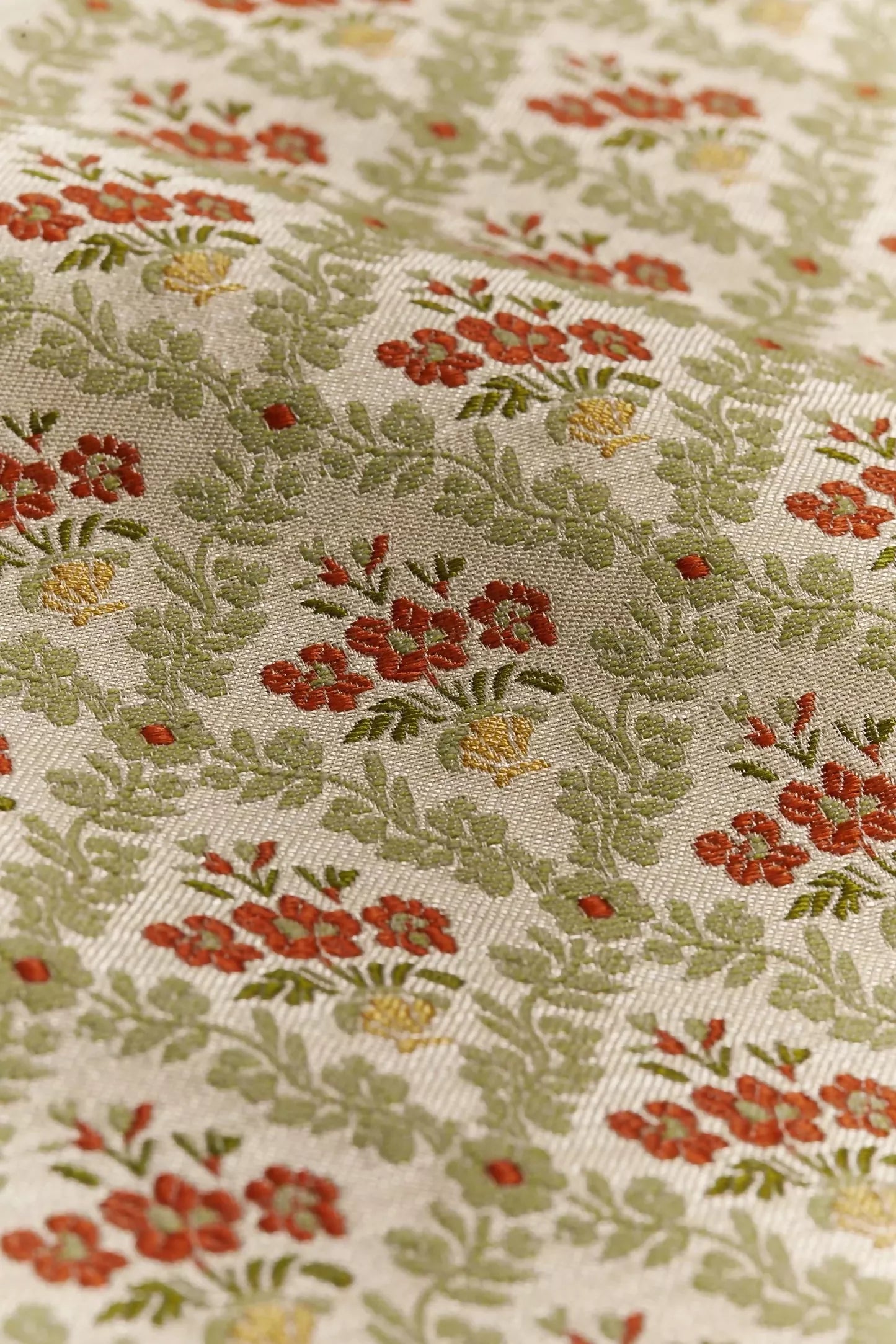 A textile fabric with a jacquard weave pattern featuring vibrant red poppies in a scallop shell vase, surrounded by foliage arranged in a trellis style,  available  to buy on the-salon.com. SALON curates the finest , unique, handmade pieces from the interior industry's best makers and brands. Shop luxury furniture, lighting, rugs, art, antiques and vintage pieces and accessories from SALON interior designed rooms.