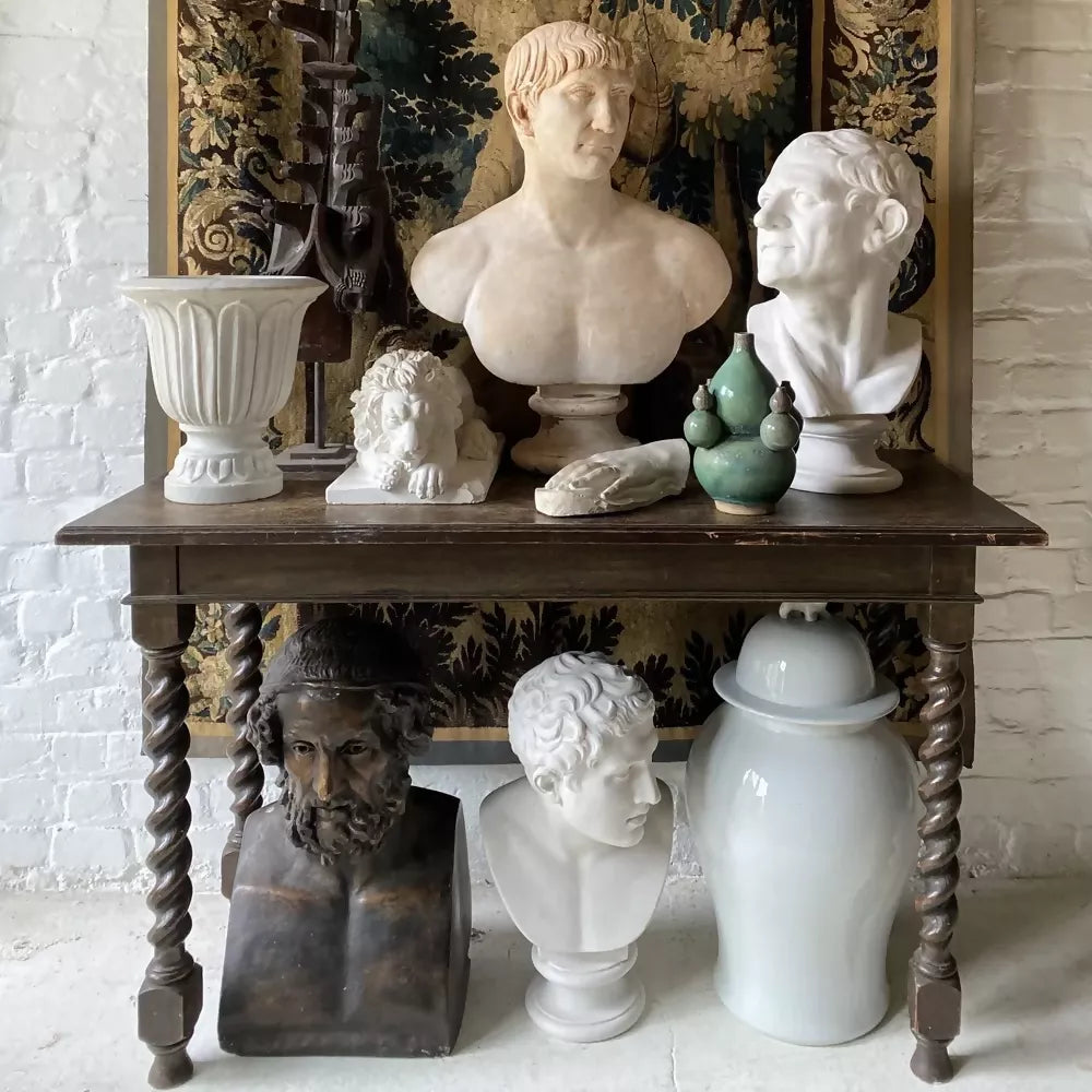 White marble bust on a pedestal with decorative wall in the background available to buy from the-salon.com. SALON curates the finest unique handmade pieces from the interior industry's best makers and brands. Shop luxury furniture, lighting, rugs, art, antiques and vintage pieces and accessories from SALON interior designed rooms.