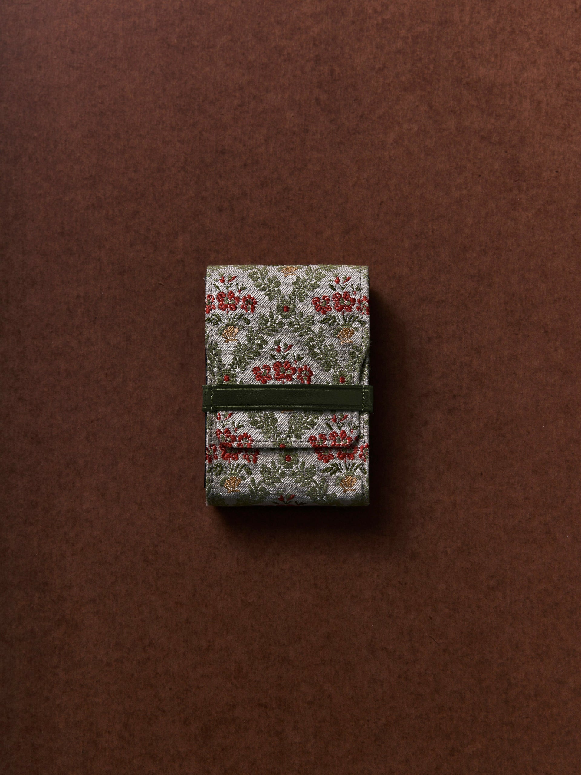 Small floral-patterned box with a green ribbon on a brown background,  available  to buy on the-salon.com. SALON curates the finest , unique, handmade pieces from the interior industry's best makers and brands. Shop luxury furniture, lighting, rugs, art, antiques and vintage pieces and accessories from SALON interior designed rooms.