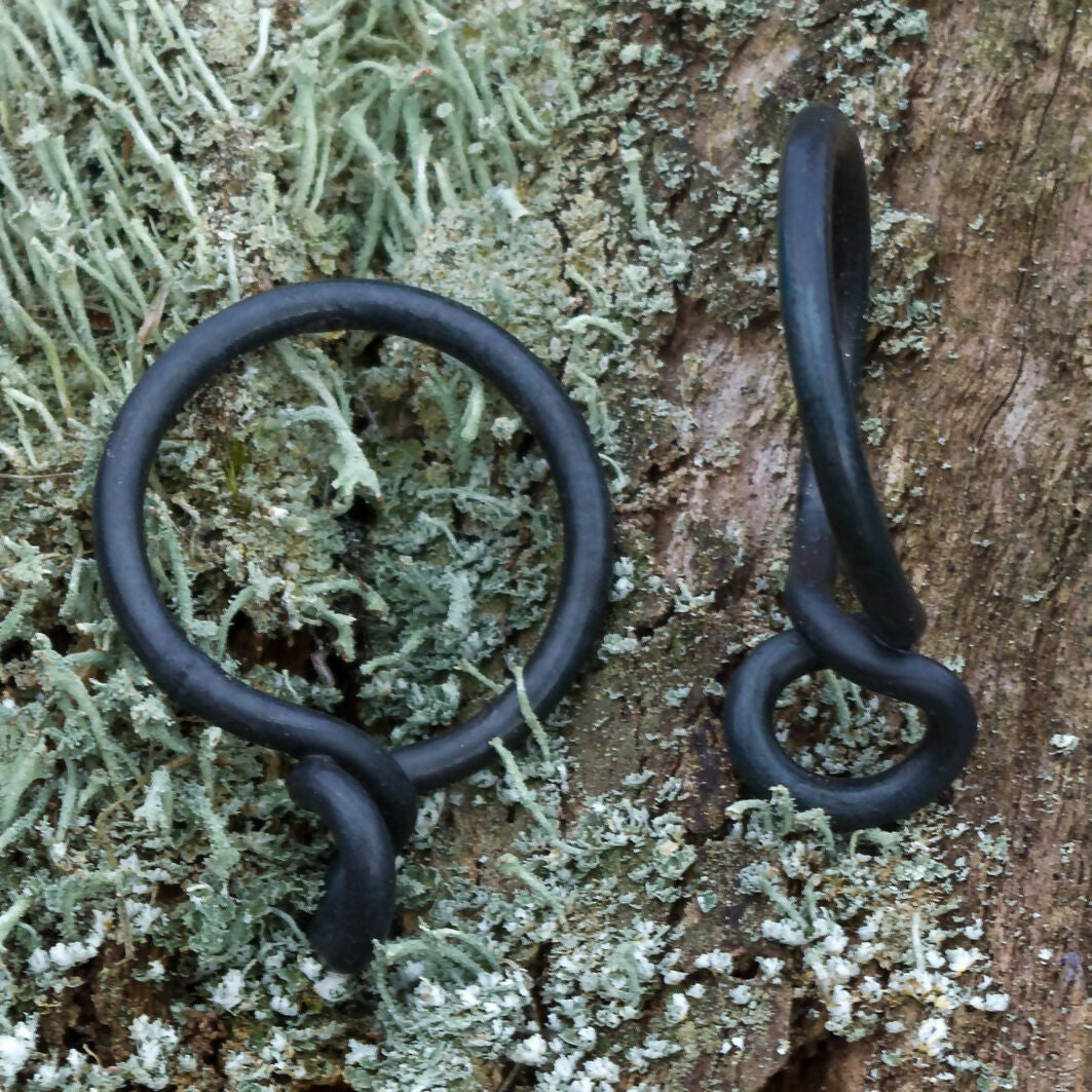 Black curtain ring displayed on a natural background, available  to buy on the-salon.com. SALON curates the finest , unique, handmade pieces from the interior industry's best makers and brands. Shop luxury furniture, lighting, rugs, art, antiques and vintage pieces and accessories from SALON interior designed rooms.