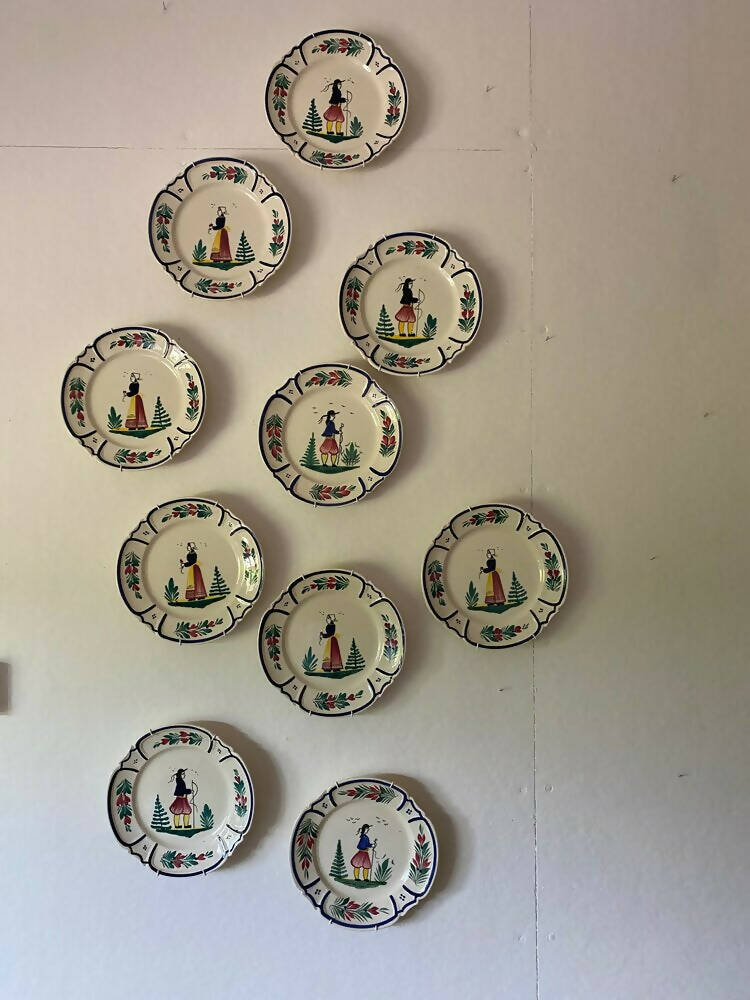 A set of vintage French hand painted plates with a man and woman motif, displayed on a wall,  available  to buy on the-salon.com. SALON curates the finest , unique, handmade pieces from the interior industry's best makers and brands. Shop luxury furniture, lighting, rugs, art, antiques and vintage pieces and accessories from SALON interior designed rooms.