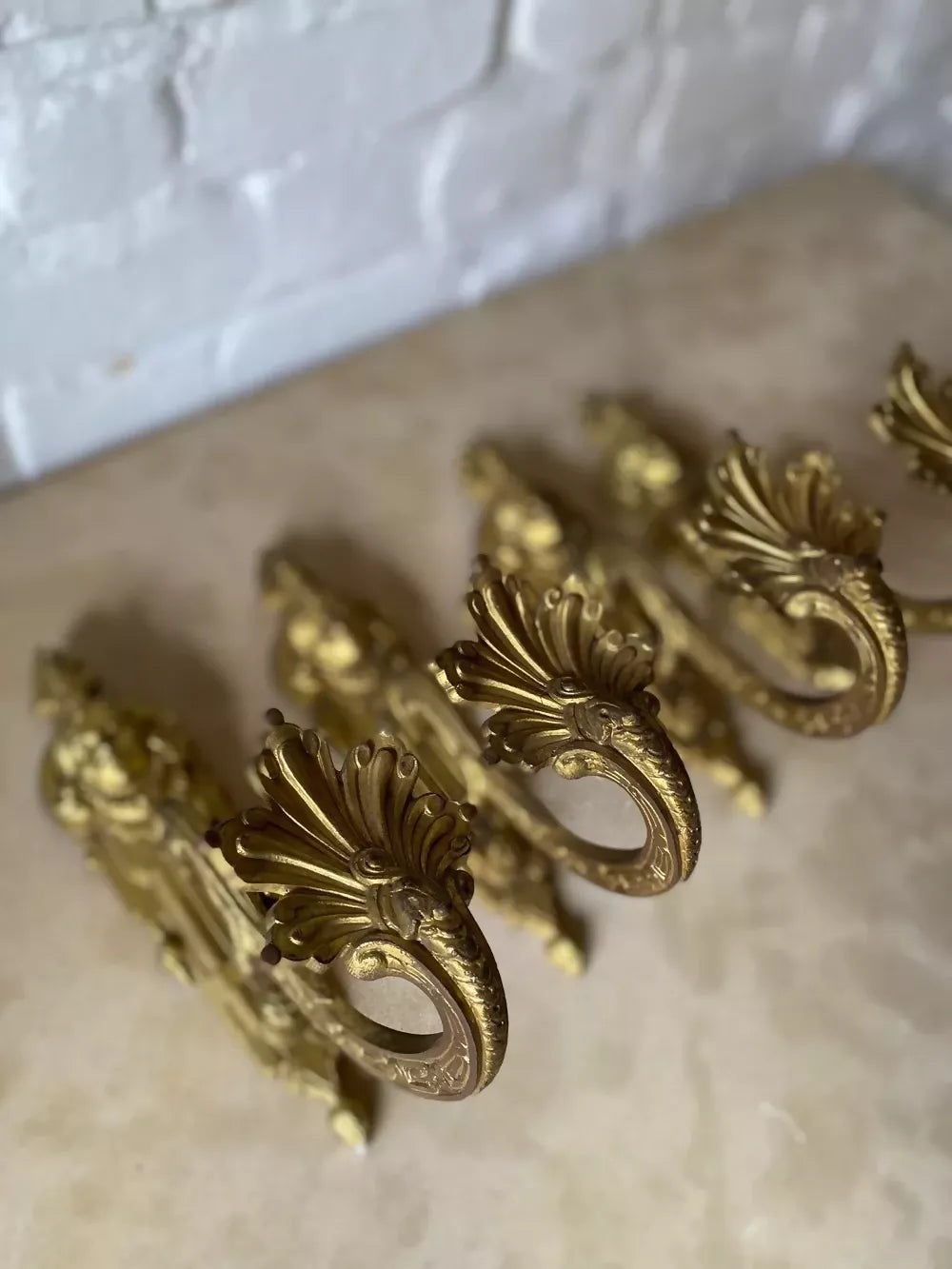 Two ornate bronze wall sconces on a marble surface available to buy from the-salon.com. SALON curates the finest unique handmade pieces from the interior industry's best makers and brands. Shop luxury furniture, lighting, rugs, art, antiques and vintage pieces and accessories from SALON interior designed rooms.