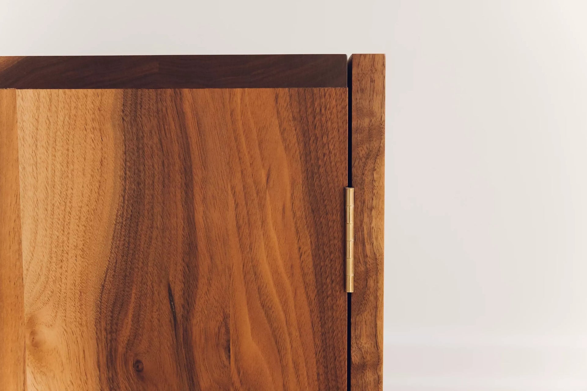 An image of the wooden cabinet, focusing on the brass butt hinges, available  to buy on the-salon.com. SALON curates the finest , unique, handmade pieces from the interior industry's best makers and brands. Shop luxury furniture, lighting, rugs, art, antiques and vintage pieces and accessories from SALON interior designed rooms.