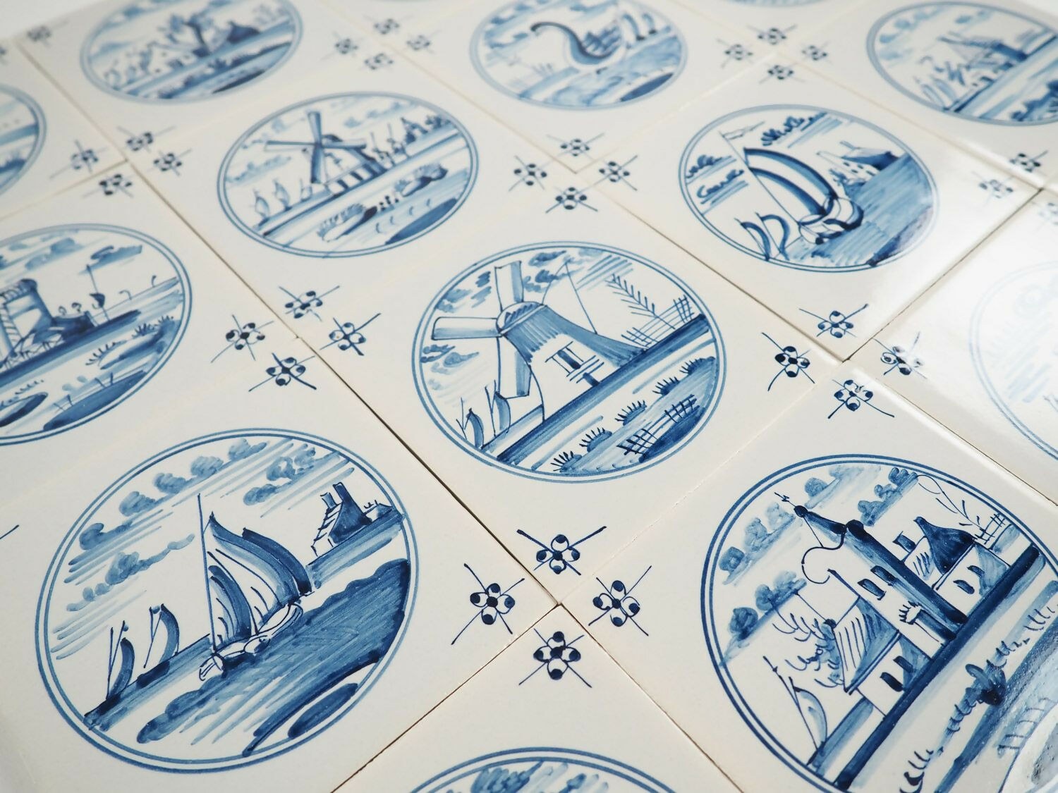 Pattern of blue and white tiles with scenic designs on a white background,  available  to buy on the-salon.com. SALON curates the finest , unique, handmade pieces from the interior industry's best makers and brands. Shop luxury furniture, lighting, rugs, art, antiques and vintage pieces and accessories from SALON interior designed rooms.