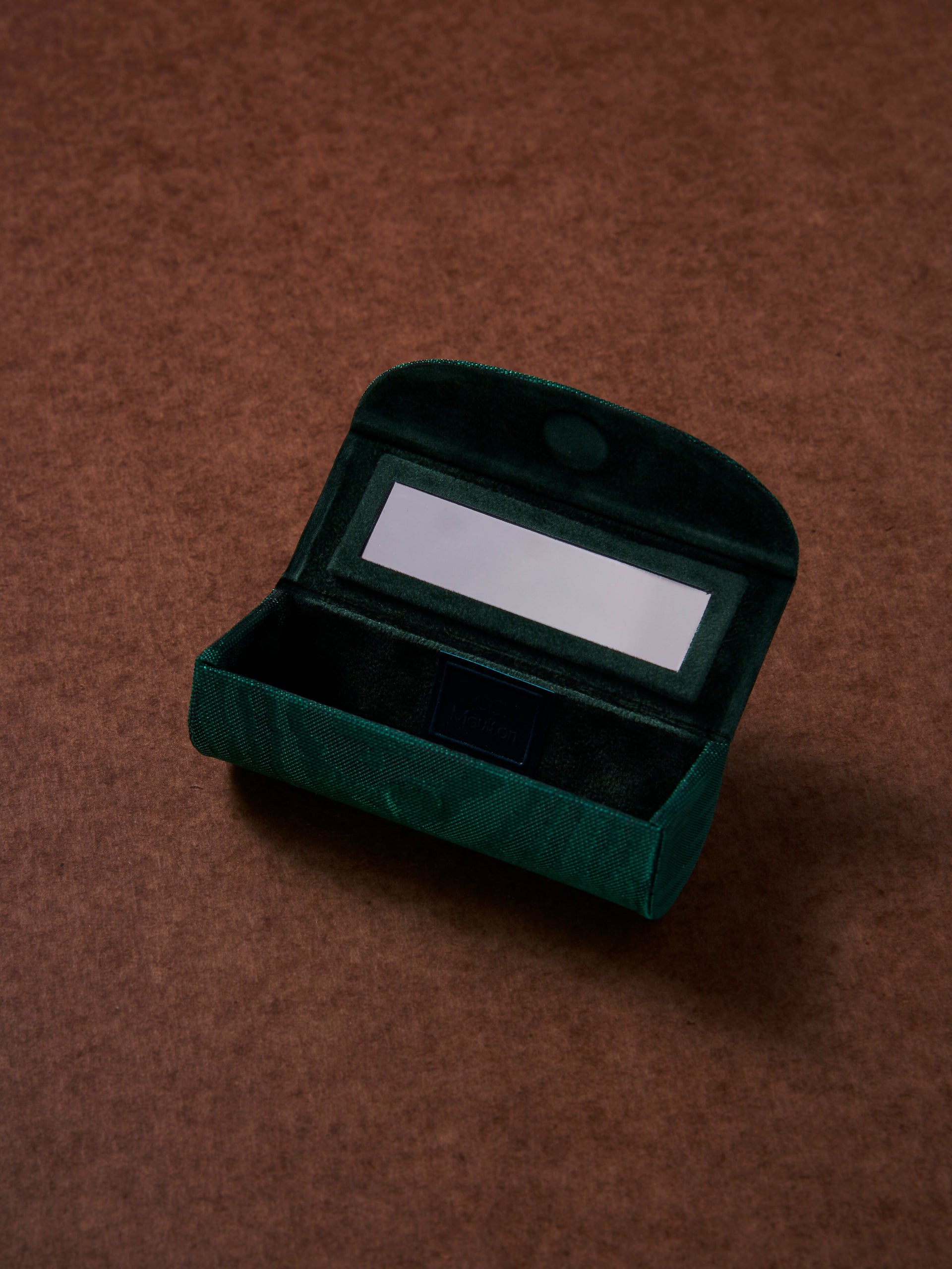 Green velvet jewelry box with a mirror on a brown background,  available  to buy on the-salon.com. SALON curates the finest , unique, handmade pieces from the interior industry's best makers and brands. Shop luxury furniture, lighting, rugs, art, antiques and vintage pieces and accessories from SALON interior designed rooms.